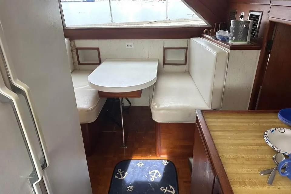 1975 Pacemaker 62 Motor Yacht interior with dining area and nautical-themed decor.