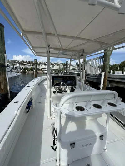 High Time Yacht Photos Pics 2004 Jupiter 31 boat interior with steering console, rod holders, and cooler at marina dock.