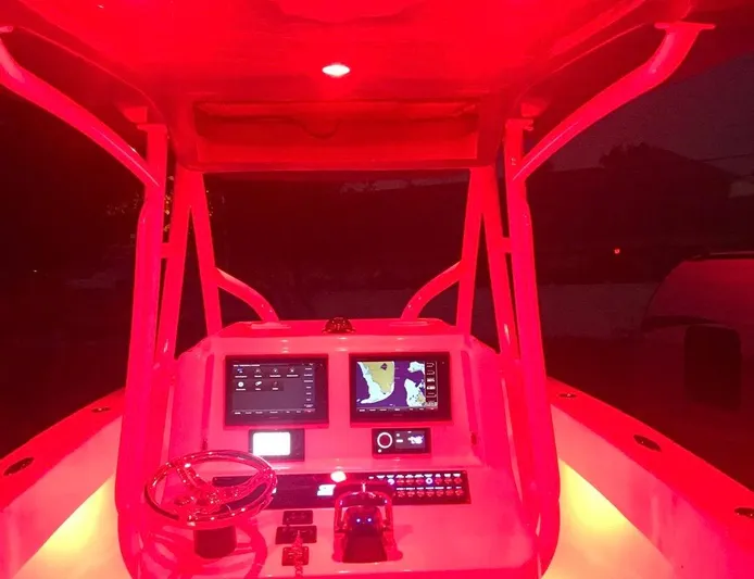  Yacht Photos Pics Red-lit cockpit of a 2019 Sea Tech 33 boat with navigation screens.