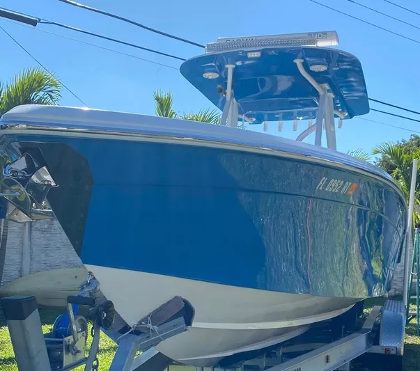  Yacht Photos Pics 2019 Sea Tech 33 boat on trailer, blue hull, sunny day, palm trees in background.