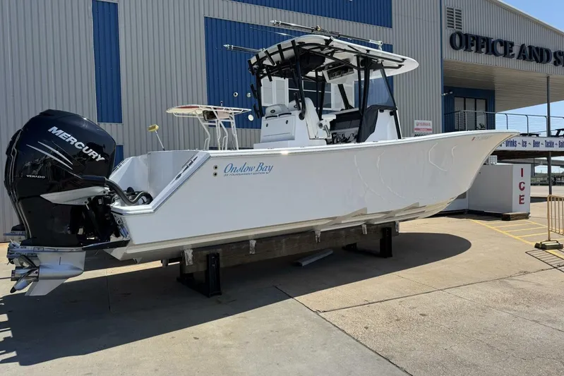  Yacht Photos Pics 2022 Onslow Bay 33 TE boat with Mercury engine, displayed outside a marine facility.