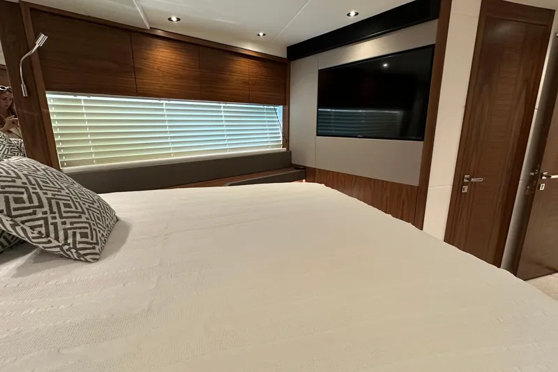 Enough Yacht Photos Pics Luxurious bedroom interior of 2023 Sunseeker 76 Yacht with modern decor and large TV.