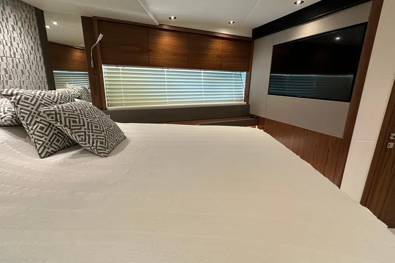 Enough Yacht Photos Pics Luxurious bedroom interior of 2023 Sunseeker 76 Yacht with modern decor and large TV.