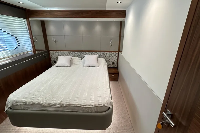 Enough Yacht Photos Pics Luxurious bedroom interior of 2023 Sunseeker 76 Yacht with modern design and cozy bedding.
