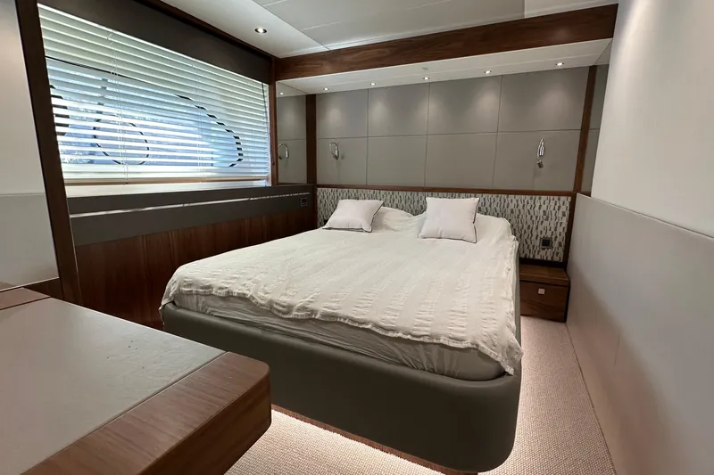 Enough Yacht Photos Pics Luxurious bedroom interior of 2023 Sunseeker 76 Yacht with modern design and cozy bedding.