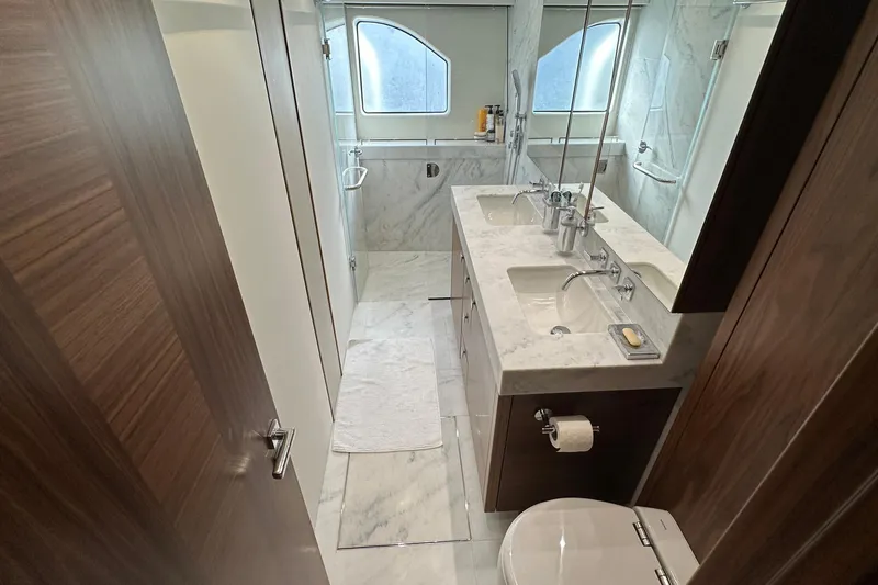 Enough Yacht Photos Pics Luxurious bathroom in 2023 Sunseeker 76 Yacht with marble countertops and modern fixtures.