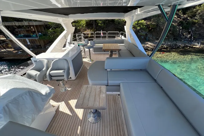 Enough Yacht Photos Pics Luxurious 2023 Sunseeker 76 Yacht deck with elegant seating and scenic ocean view.