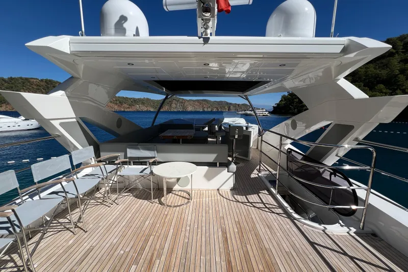 Enough Yacht Photos Pics Luxurious 2023 Sunseeker 76 Yacht deck with seating, overlooking serene blue waters.