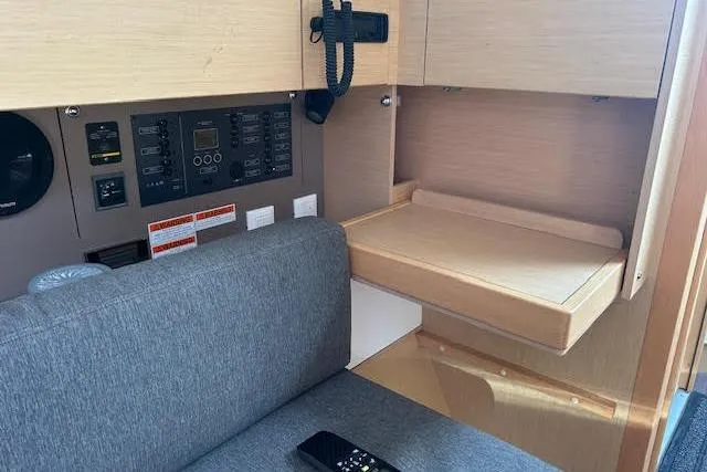 Hummingbird Yacht Photos Pics Interior of 2017 Beneteau Oceanis 38.1 yacht with control panel and seating area.