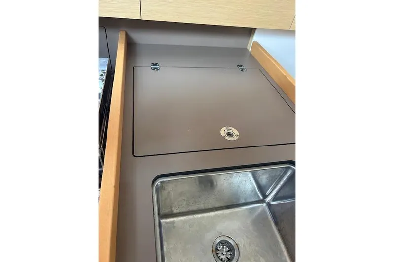 Hummingbird Yacht Photos Pics Beneteau Oceanis 38.1 2017 yacht kitchen sink with brown countertop and wooden accents.