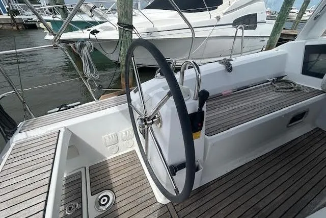 Hummingbird Yacht Photos Pics 2017 Beneteau Oceanis 38.1 sailboat cockpit with steering wheel and wooden deck.