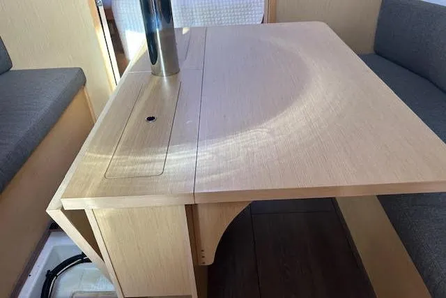 Hummingbird Yacht Photos Pics Interior of 2017 Beneteau Oceanis 38.1 yacht, featuring a wooden dining table and seating.