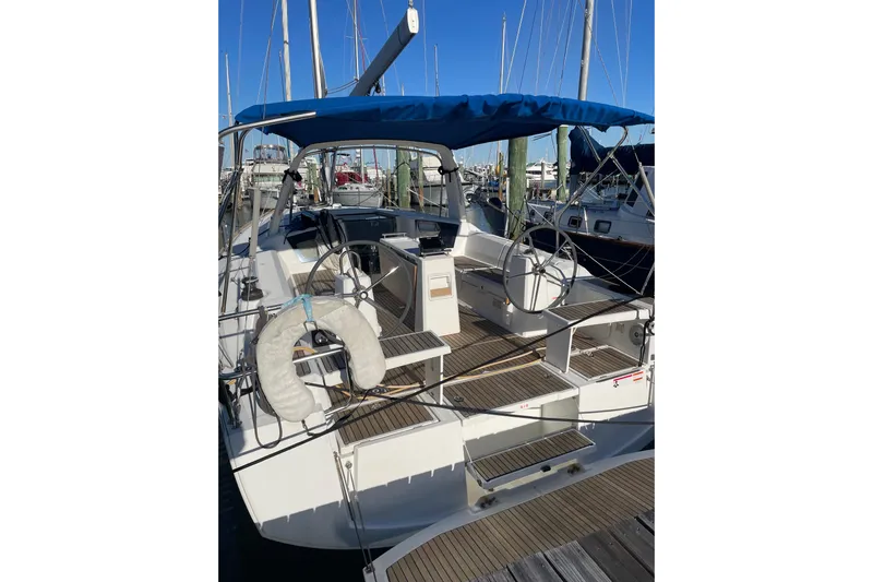 Hummingbird Yacht Photos Pics 2017 Beneteau Oceanis 38.1 sailboat with blue canopy docked at marina.