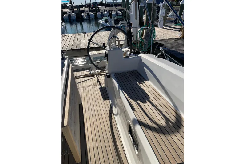 Hummingbird Yacht Photos Pics 2017 Beneteau Oceanis 38.1 sailboat cockpit with wooden deck and steering wheel at marina.