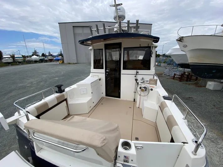  Yacht Photos Pics 2017 Cutwater C-28 boat with spacious deck and seating, docked near a storage facility.