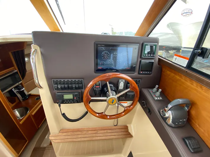  Yacht Photos Pics 2017 Cutwater C-28 helm with wooden steering wheel and modern navigation controls.