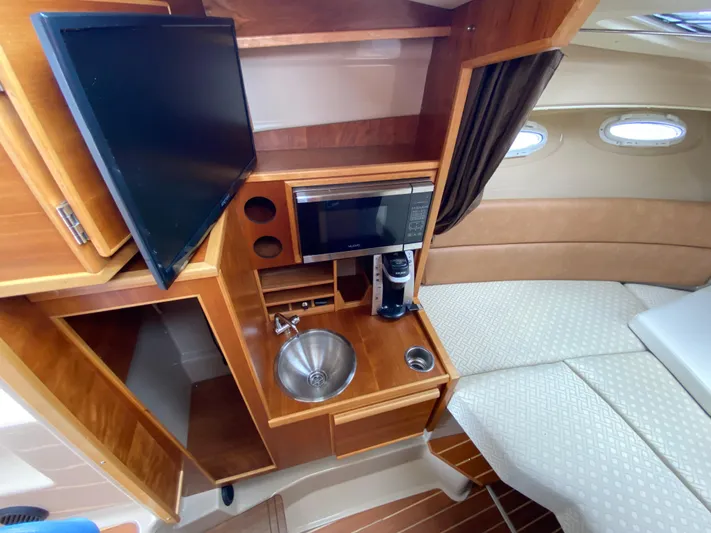  Yacht Photos Pics 2017 Cutwater C-28 interior with kitchenette, sink, microwave, and cozy seating area.