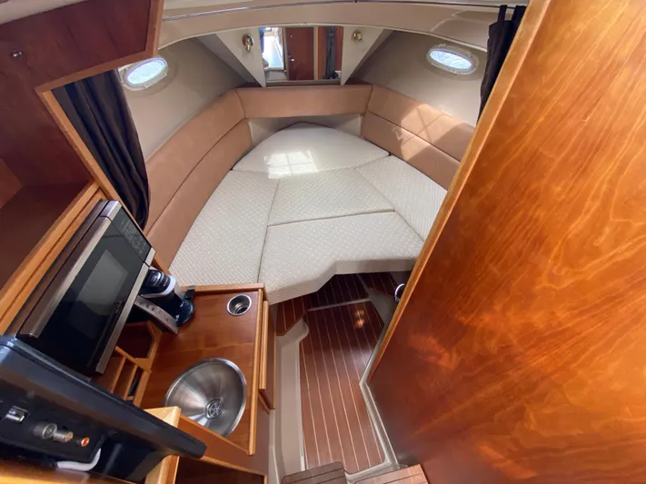  Yacht Photos Pics 2017 Cutwater C-28 cabin interior with bed, kitchenette, and wood finish.