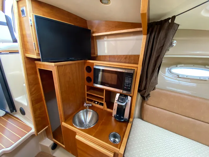  Yacht Photos Pics 2017 Cutwater C-28 interior with kitchenette, TV, microwave, and sink. Cozy and functional boat cabin.