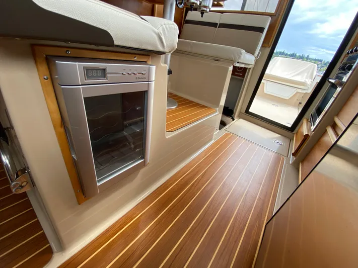  Yacht Photos Pics Interior of a 2017 Cutwater C-28 boat with wood flooring and compact fridge.