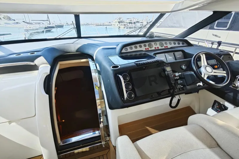  Yacht Photos Pics Interior view of 2009 Princess V58 yacht cockpit with steering wheel and control panel.