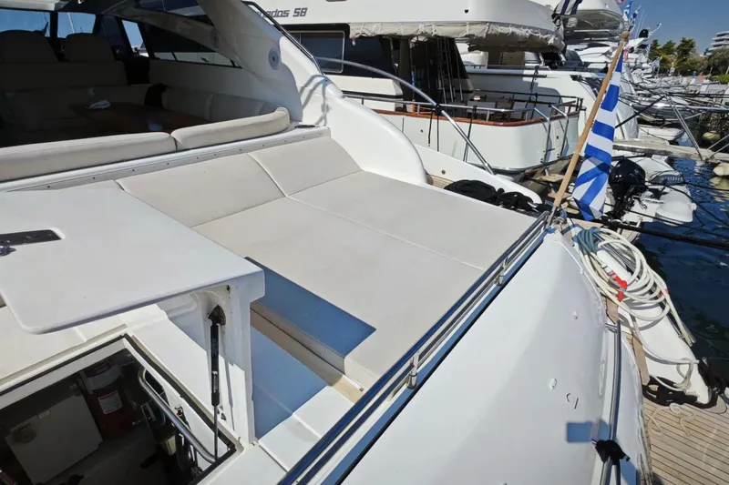  Yacht Photos Pics 2009 Princess V58 yacht with sun deck, docked in marina, featuring Greek flag.