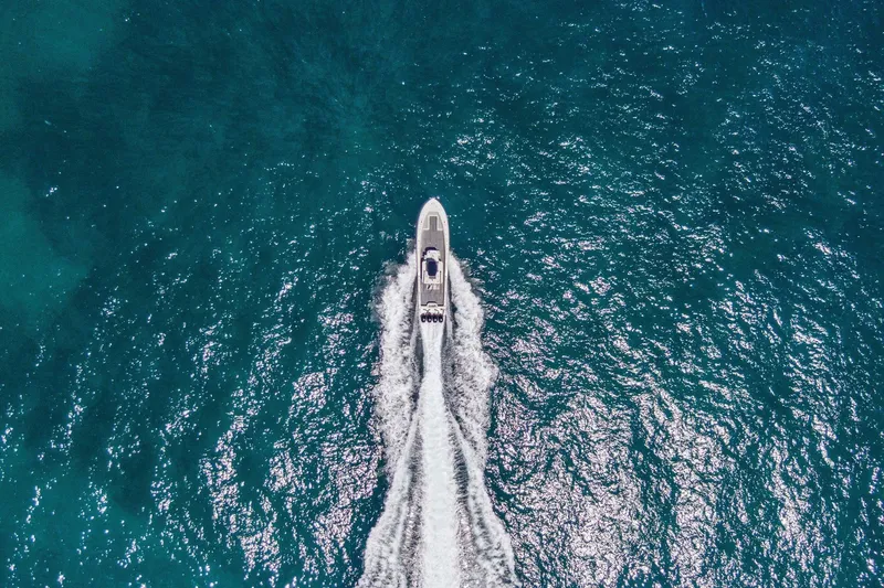  Yacht Photos Pics Aerial view of 2013 Invincible 42 Open Fisherman boat cruising on blue ocean waters.