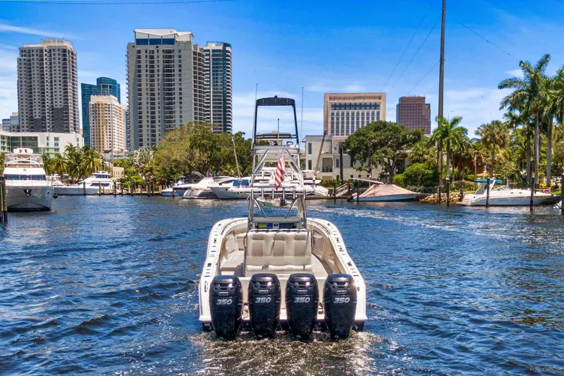  Yacht Photos Pics 2013 Invincible 42 Open Fisherman boat cruising in urban waterfront setting.