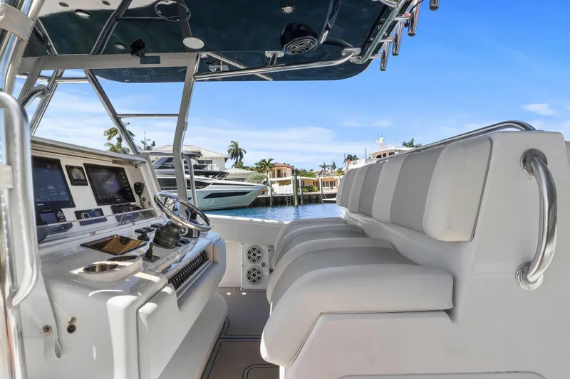  Yacht Photos Pics 2013 Invincible 42 Open Fisherman boat interior with helm and seating, docked by waterfront homes.