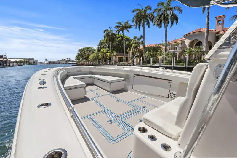  Yacht Photos Pics 2013 Invincible 42 Open Fisherman boat with spacious deck, docked near luxury waterfront homes.