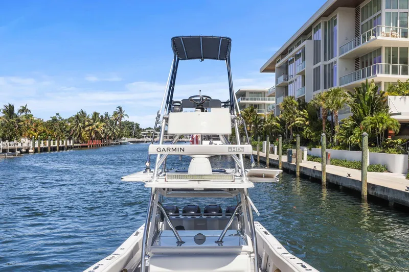  Yacht Photos Pics 2013 Invincible 42 Open Fisherman boat docked near waterfront buildings and palm trees.
