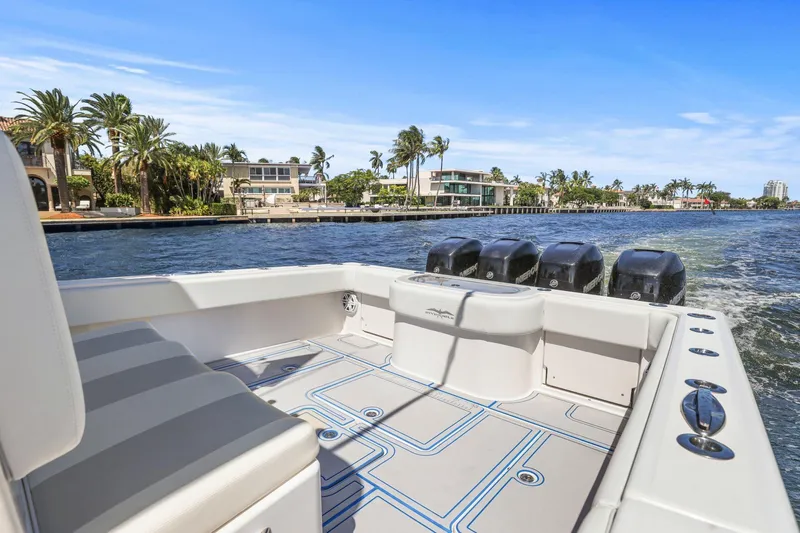  Yacht Photos Pics 2013 Invincible 42 Open Fisherman boat cruising on a sunny waterfront with palm trees.
