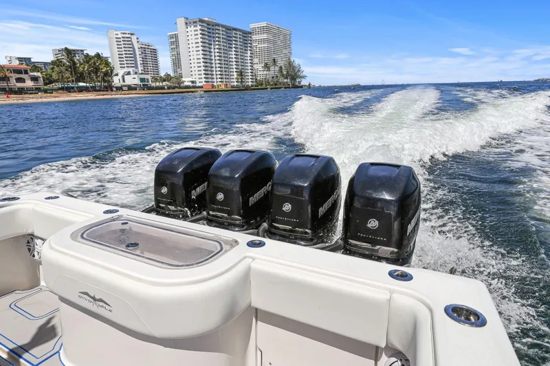  Yacht Photos Pics 2013 Invincible 42 Open Fisherman boat with four powerful engines cruising near city skyline.
