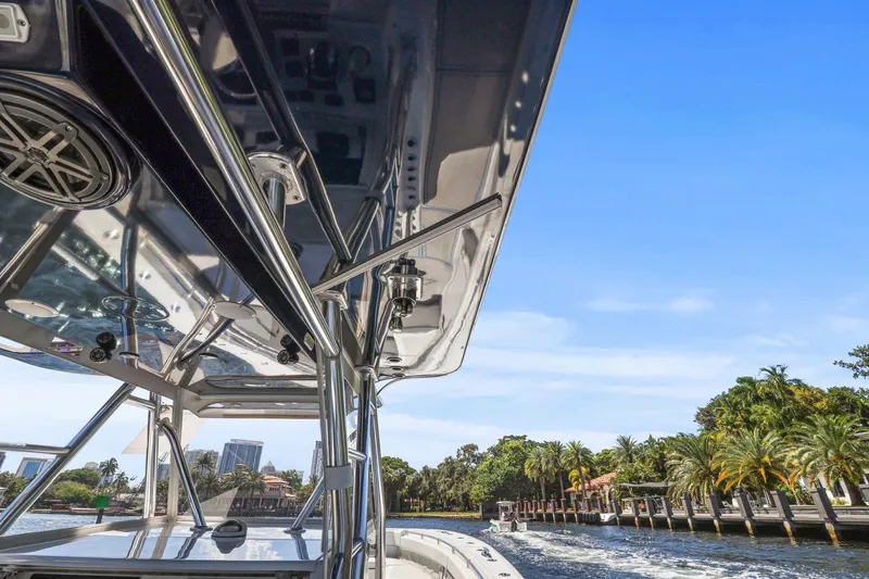  Yacht Photos Pics 2013 Invincible 42 Open Fisherman boat cruising near palm-lined waterfront.