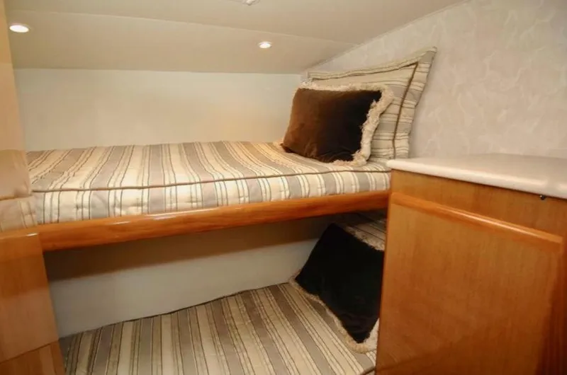Irish Mist Yacht Photos Pics Cozy cabin interior of 2001 Post 50 Convertible with striped bedding and wooden accents.