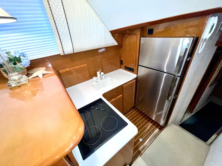 Irish Mist Yacht Photos Pics Compact kitchen in a 2001 Post 50 Convertible yacht with modern appliances and wooden cabinetry.