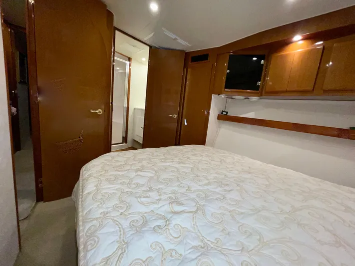 Irish Mist Yacht Photos Pics Luxurious bedroom interior of 2001 Post 50 Convertible yacht with wood cabinetry and cozy bedding.