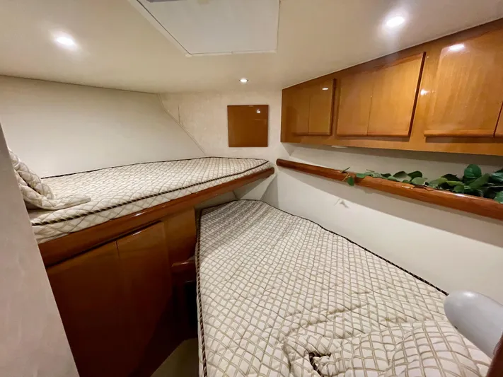 Irish Mist Yacht Photos Pics Interior cabin of 2001 Post 50 Convertible yacht with twin beds and wooden cabinets.