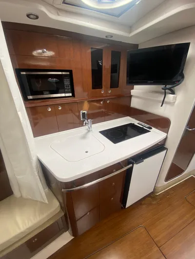 The Mint Yacht Photos Pics 2018 Four Winns 355 Vista yacht kitchen with microwave, sink, stove, and TV.