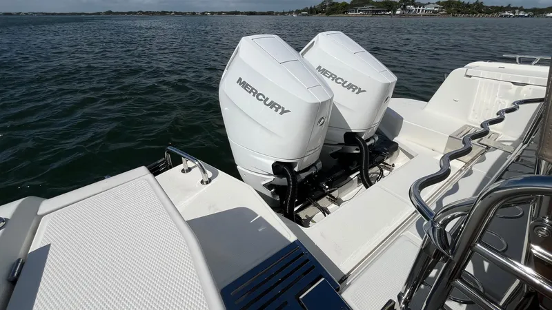 In- Stock 2025 Nimbus C11 #086 Yacht Photos Pics Twin Mercury outboard engines on a 2025 Nimbus Commuter 11 boat, docked on calm water.