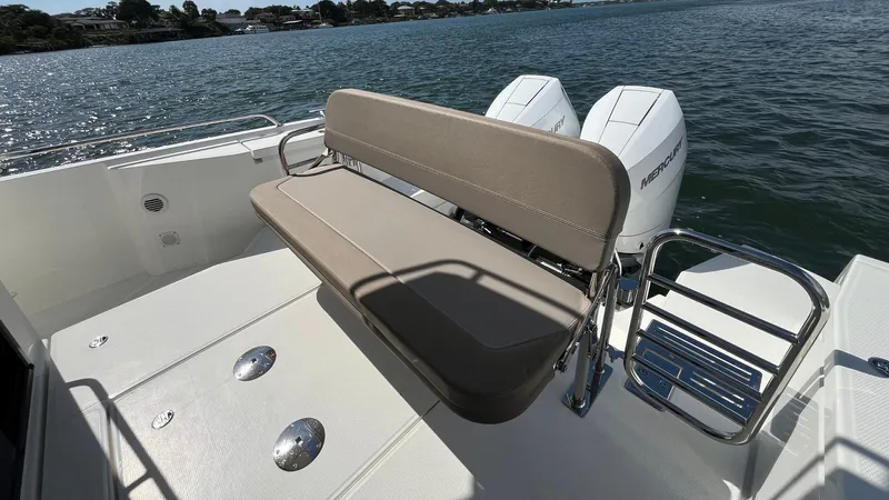 In- Stock 2025 Nimbus C11 #086 Yacht Photos Pics 2025 Nimbus Commuter 11 boat with cushioned seating and dual outboard motors on a sunny day.