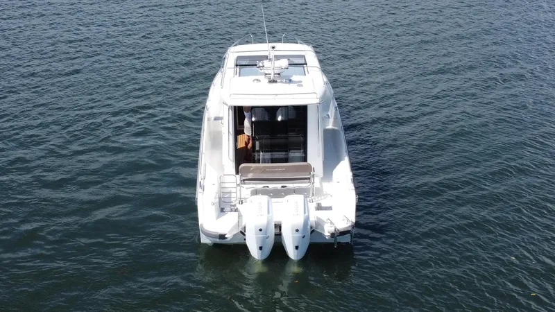 In- Stock 2025 Nimbus C11 #086 Yacht Photos Pics Nimbus Commuter 11 #086, 2025 model, white boat on calm water, rear view.