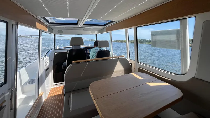 In- Stock 2025 Nimbus C11 #086 Yacht Photos Pics Interior of 2025 Nimbus Commuter 11 boat with panoramic windows and seating.