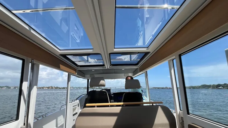 In- Stock 2025 Nimbus C11 #086 Yacht Photos Pics Interior view of 2025 Nimbus Commuter 11 boat with panoramic windows and scenic water backdrop.