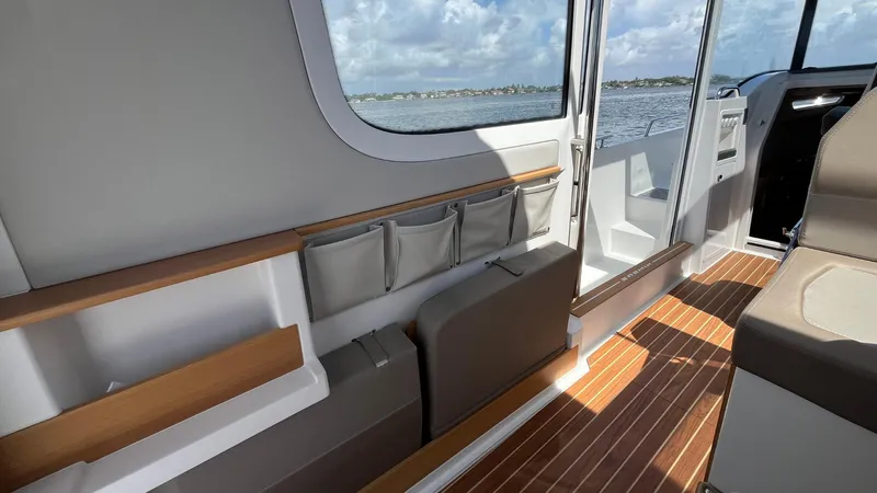 In- Stock 2025 Nimbus C11 #086 Yacht Photos Pics Interior of 2025 Nimbus Commuter 11 boat with wooden flooring and seating.