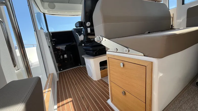 In- Stock 2025 Nimbus C11 #086 Yacht Photos Pics Interior of 2025 Nimbus Commuter 11 boat with seating and wooden storage.