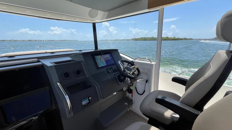 In- Stock 2025 Nimbus C11 #086 Yacht Photos Pics Interior of 2025 Nimbus Commuter 11 boat, featuring modern helm and scenic ocean view.