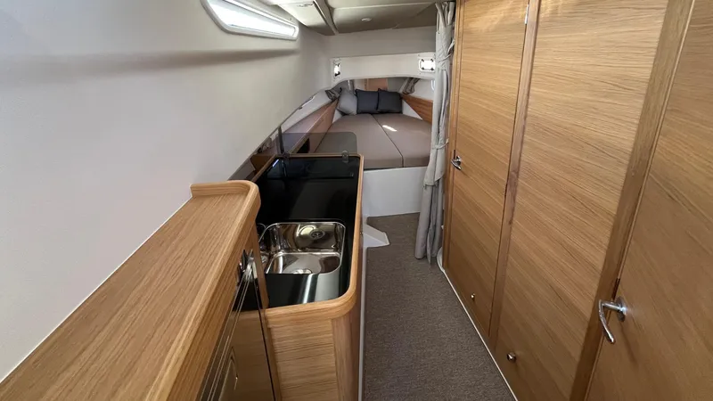 In- Stock 2025 Nimbus C11 #086 Yacht Photos Pics Interior of 2025 Nimbus Commuter 11 #086, featuring a compact kitchen and cozy sleeping area.