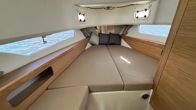 In- Stock 2025 Nimbus C11 #086 Yacht Photos Pics Luxurious interior cabin of 2025 Nimbus Commuter 11, featuring cozy bedding and wooden accents.