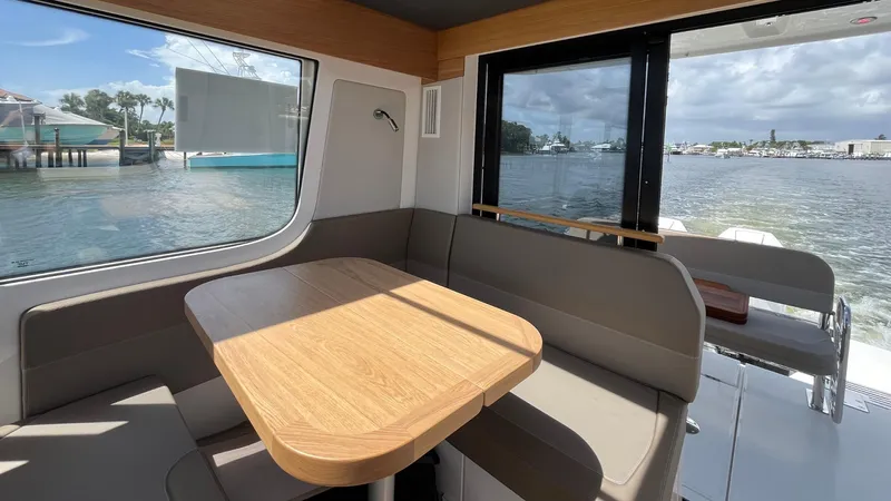 In- Stock 2025 Nimbus C11 #086 Yacht Photos Pics Interior of 2025 Nimbus Commuter 11 boat with dining area and waterfront view.